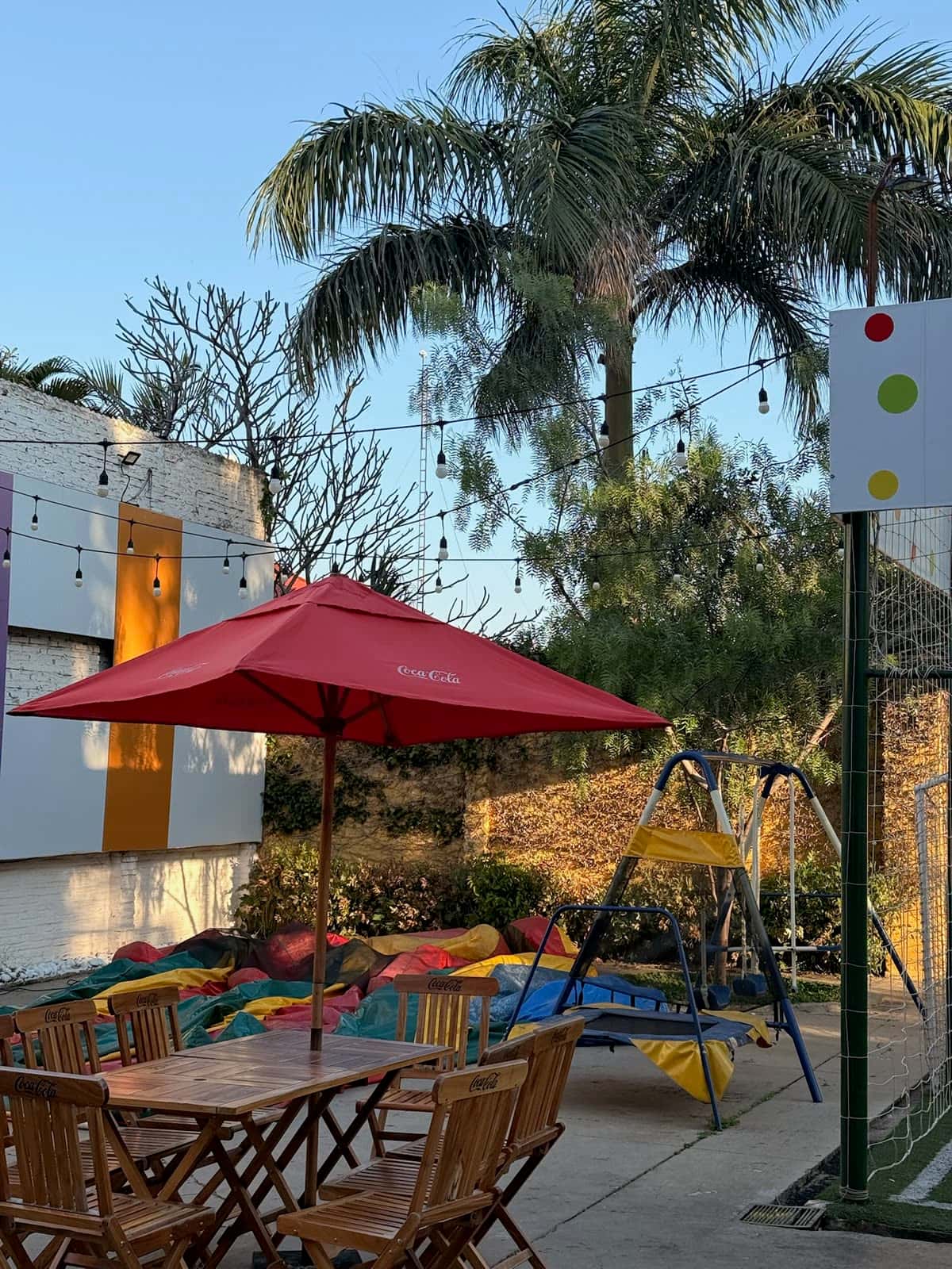 Patio al aire libre con mesas, sombrilla y luces